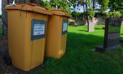 Fototapeta na wymiar Garden waste bins in a graveyard