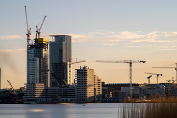 Obraz premium A long exposure cityscape of Kalasatama residential district under construction during sunset.