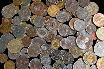 Scattering of coins from different countries and continents. Background image. Coins of the USA, Thailand, Switzerland, Tunisia, Czech Republic, United Arab Emirates, Egypt, Croatia, Turkey and others