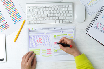 Web site developer creates a sketch of the interface on the desktop. The designer draws the project...