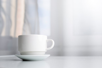 White cup of morning tea or coffee. Place for text.