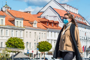 Beautiful girl with mask walking in the city center during Covid or Coronavirus days