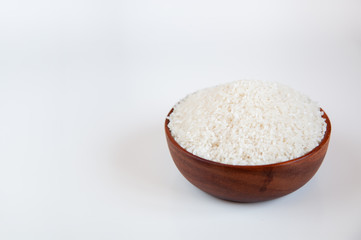White rice in a wooden bowl on a light background.