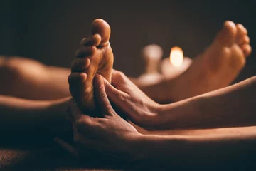 Fotobehang Professional foot massage close up. Authentic shot of luxury spa treatment. Charming light. Shallow depth of field. Stylized and colored. © gudenkoa