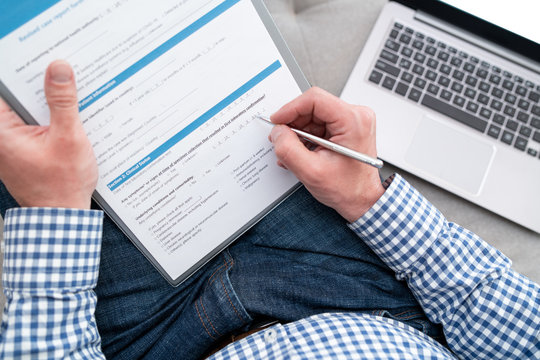 A Man Fills Out A Medical Form For Coronavirus Test. He Is On Quarantine.