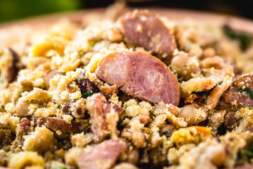 Beans with pork, called tropeiro beans, typical food from Minas Gerais. Fried sausage, farofa, baked beans, parsley and scallions.