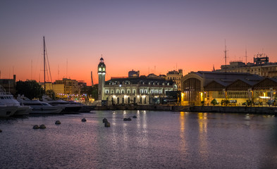 Valencia harbor, Sunset marina port Spanish city nautical scene warm red colors. Port Authority buildings with clock tower