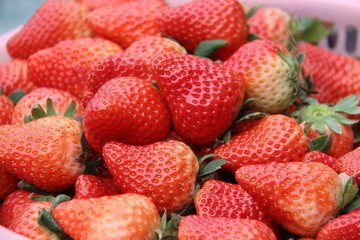 Closeup of a pile of ripe organic strawberries in a plate