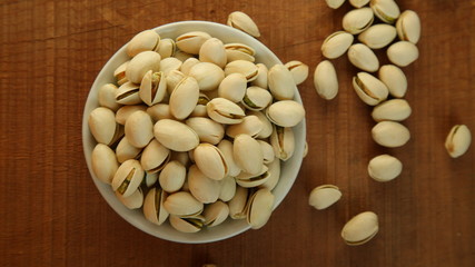 Top view of pistachios in a plate on the table, organic nuts
