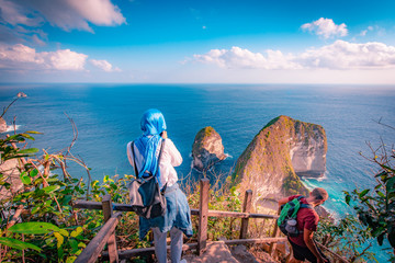 Girl standing on a cliff and enjoys the view to trex mountain on nusa penida island in bali ,Indonesia. © chanchai