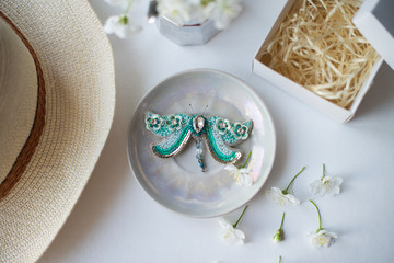 butterfly made of beads made with their own hands on a plate of straw sun