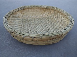 Empty wicker basket, handwoven round threshing basket on the ground