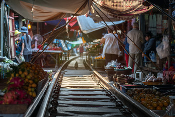 Thailand, Samut Songkhrami, Mae Klong railway market also called Siang Tai. Tourists walk along the train tracks. and make purchases from local sellers. Po place among tourists from all over the world