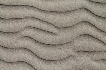 Fototapeta na wymiar Texture of dry sand surface with horizontal ripples