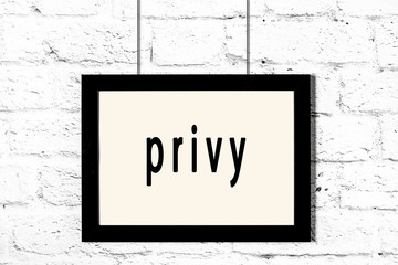 Black frame hanging on white brick wall with inscription privy © iushakovsky