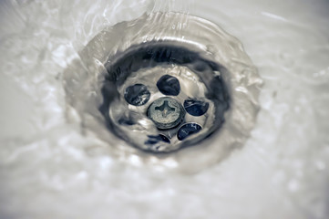 water flow into drain in white bath