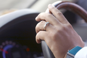 Hand holding car steering wheel, car driving