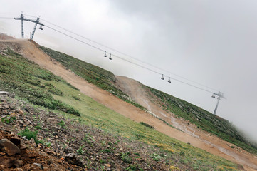 Mountain landscape with cable car in the fog.