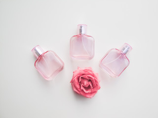  Set of colored cosmetic bottles, ampoules, tubes, cans on a white background. Pink bottles with flowers, aroma concept