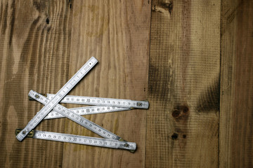 Folding ruler on wooden background