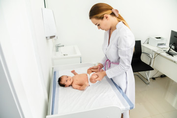 Obraz premium medicine, healthcare and pediatrics concept - female pediatrician or neuropathist doctor or nurse checking baby patient's at clinic or hospital