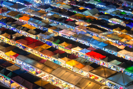 Bangkok, Thailand, Top view of Train Night Market Ratchada flea market with plenty of shops with colorful canvas and amazing pattern of roofs near MRT line at night time in Bangkok