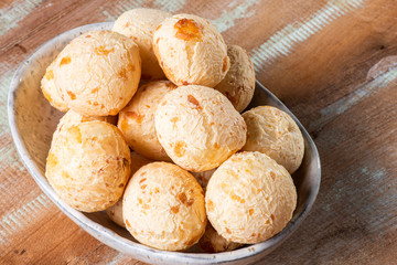 Brazilian cheese bread in a bowl. Wood background.