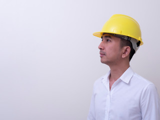 engineer with hands crossed wearing yellow helmet on white background