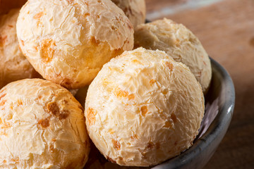 Brazilian cheese bread in a bowl. Wood background.