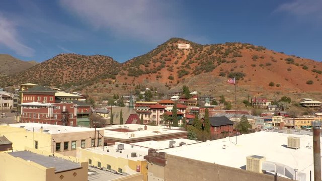 Rooftops Of Old Buildings In Bisbee, Arizona With Mule Mountains On The Background On A Sunny Day. - aerial panning shot