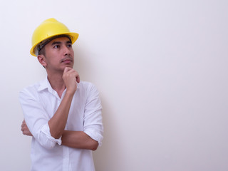 engineer with hands crossed wearing yellow helmet on white background