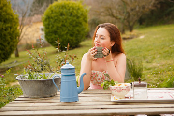 girl drinks tea from vintage teapot and mug