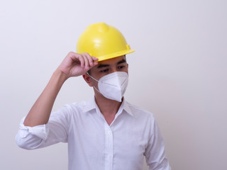 Asian industrial workers wear yellow hard hats, wear protective masks for their health