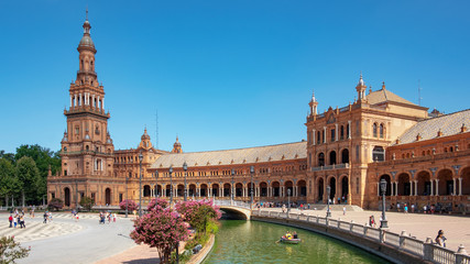 Fototapeta na wymiar Plaza de Espana, impressive architectural complex featuring different styles and elements: water canals, bridges and two Spanish Baroque towers at each end, Seville, Andalusia, Spain