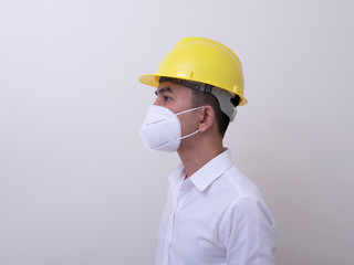 Asian industrial workers wear yellow hard hats, wear protective masks for their health