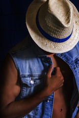 young African man with jlet of jeanz and face covered with straw hat