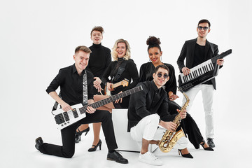 Multiracial music band on a white background. A group of international musicians rehearsing a...