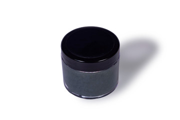 Natural face black charcoal scrub mask in container isolated on white background.