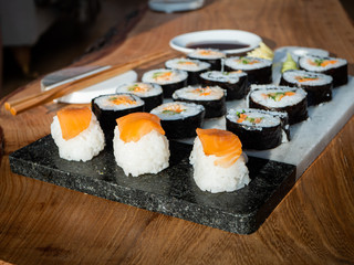 Set of sushi on a chopping board with chopsticks and soy sauce