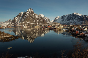 Obraz premium View of beautiful Sacrisoya village in winter time with montains in background with light of sunrise. Lofoten, Norway.