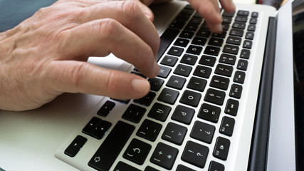 hands using keyboard of laptop