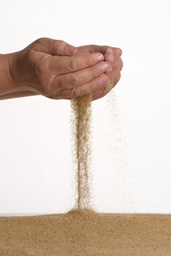 Stop motion. From the palm of the sand flows down. Male hands.