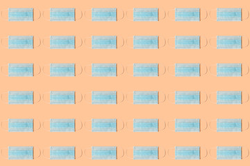 COVID-19 pattern of surgical face masks on orange background. Protection against coronavirus. Healthcare and medical concept with copy space