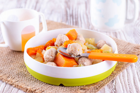 Stewed vpumpkin, potatoes, zucchini and meatballs as dinner for baby. Baby food in children's dishes