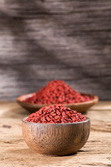 annatto seeds in bowl on wooden background