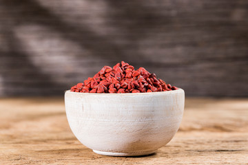 annatto seeds in bowl on wooden background