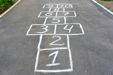 Playing hopscotch on the playground outdoors, children outdoor activities