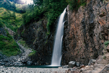 Fototapeta na wymiar Beautiful multi-tiered waterfall long exposure in mountain forest.