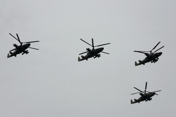 A group of reconnaissance and attack helicopters Ka-52 Alligator (Hokum B) fly in the sky over Red Square during an air parade dedicated to Victory Day in World War II