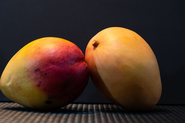 Fresh pink mango fruits ((Mangifera indica) on dark background